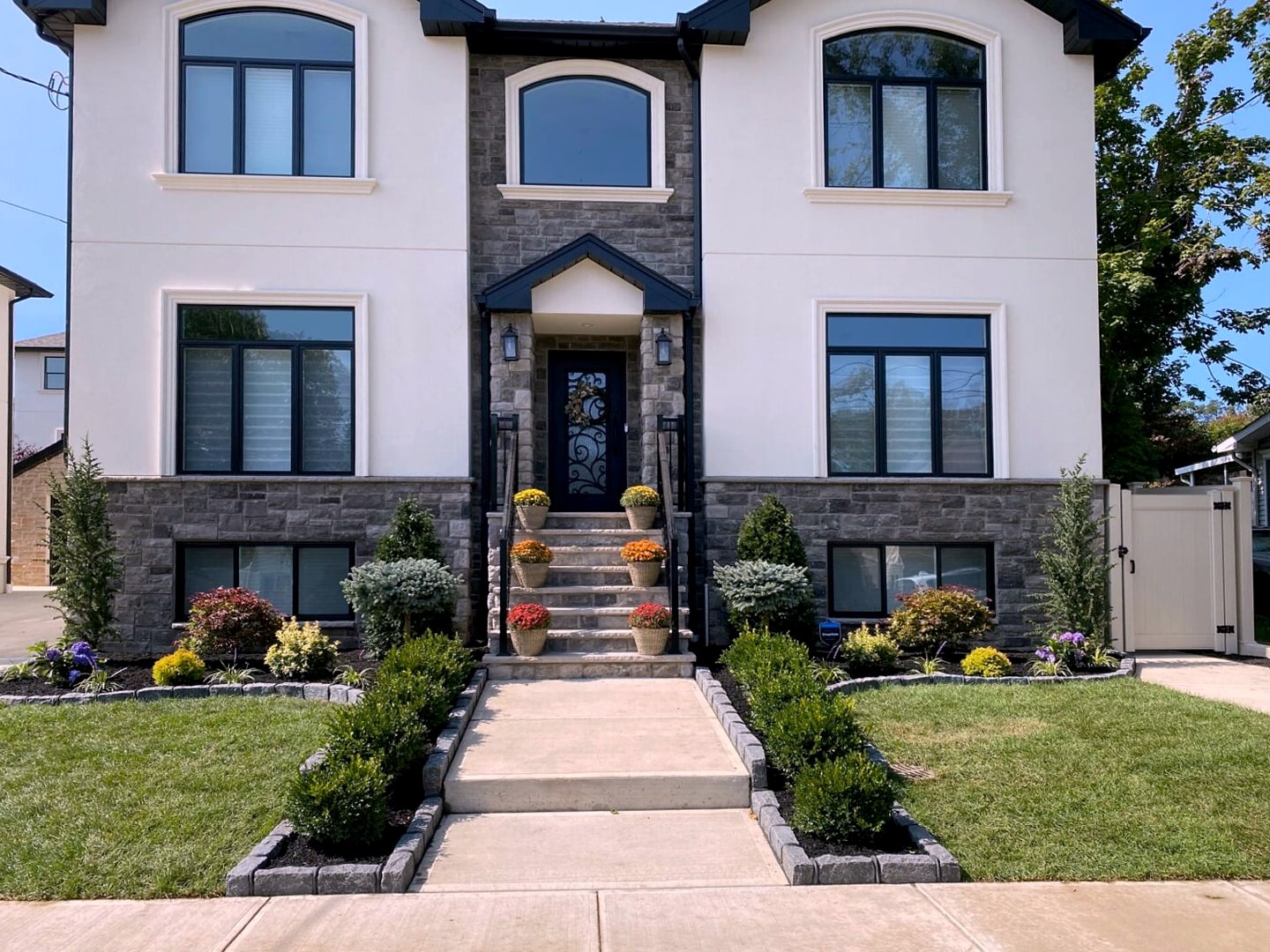 Stucco and stone house with landscaped front beds and steps